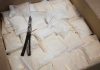 Bags of white powder with scissors in cardboard box