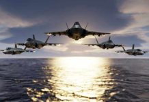 Five jets flying low over the ocean at sunset