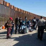 Border patrol agents interact with a group of people