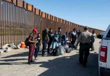Border patrol agents interact with a group of people