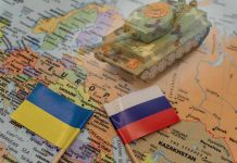 Toy tank on map with Ukraine and Russia flags.