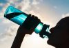 Silhouette of person drinking from a water bottle