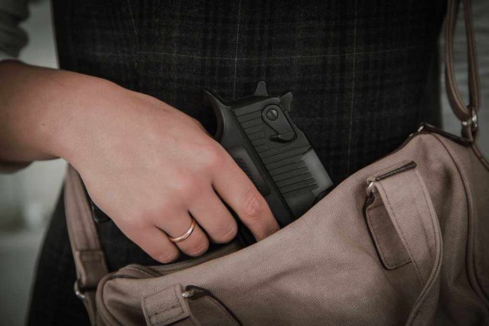 Hand placing handgun into beige handbag