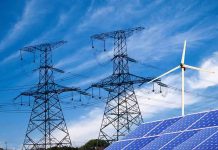 Solar panels and a wind turbine with power lines against a blue sky