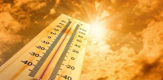 A thermometer displaying temperature against a sunset sky