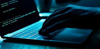 Hand typing on laptop with code on screen