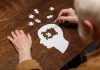 Elderly person completing head shaped jigsaw puzzle