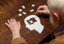 Elderly person completing head shaped jigsaw puzzle