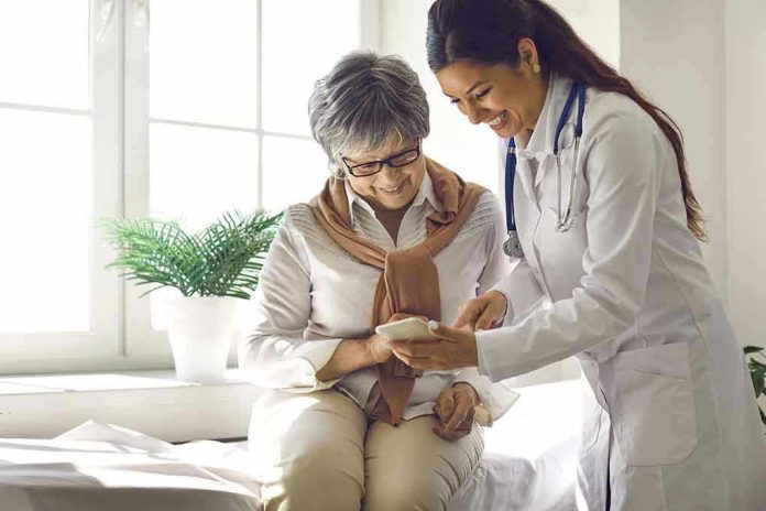 Doctor showing phone to a smiling elderly woman