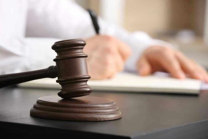 2454469737 Judge's gavel on desk with person writing.
