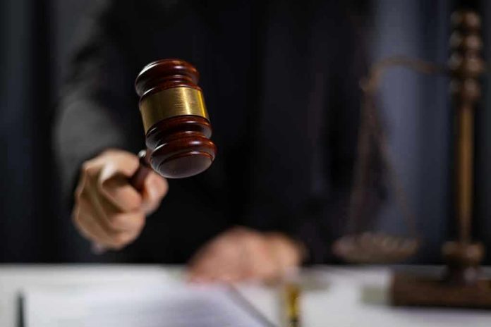 Hand holding gavel in courtroom setting