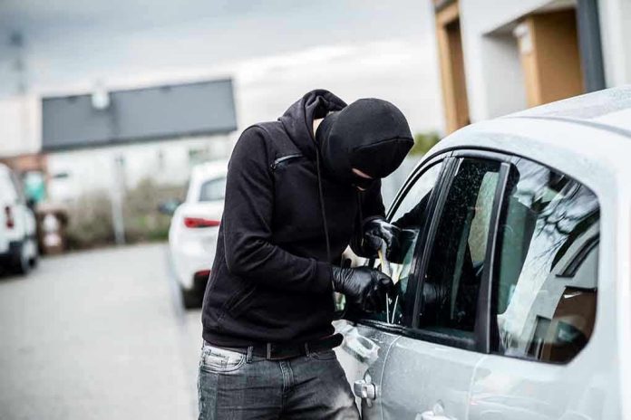 420540250 Person in black breaking into a car