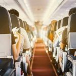 Passengers seated inside an airplane cabin.