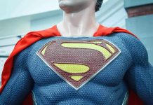 Close-up of a Superman statue wearing a blue costume and red cape