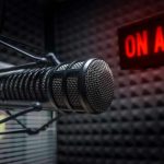Howard Stern Puts SiriusXM Return on Hold Microphone in soundproof studio with On Air sign.