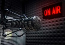 Microphone in soundproof studio with On Air sign.
