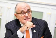 Man in suit with glasses thinking deeply.