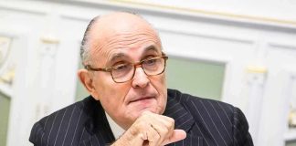Man in suit with glasses thinking deeply.