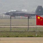 Jet with 31001 marking behind barbed wire fence