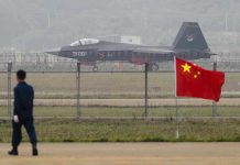 Jet with 31001 marking behind barbed wire fence