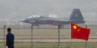 Jet with 31001 marking behind barbed wire fence