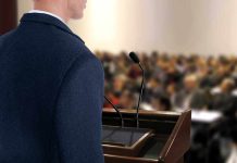 A speaker at a podium addressing an audience