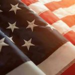 Extremist Group Deputized? Fear Looms Over Proposal Close up of American flag with sunlit background