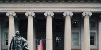 US Treasury Department building with statue and flag