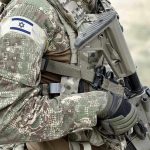 Soldier in camouflage gear with Israeli flag patch