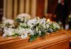 Flower arrangement on a wooden casket at a funeral