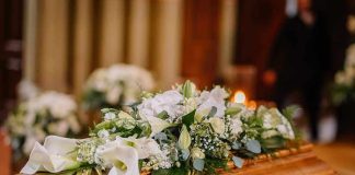 Flower arrangement on a wooden casket at a funeral