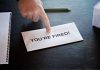 Envelope with YOURE FIRED and pointing finger