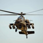 Military Apache helicopter flying in the sky
