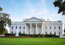 The White House with a fountain and green lawn in front