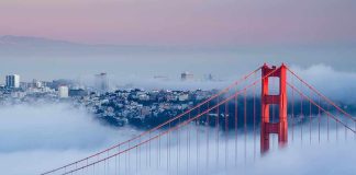 Golden Gate Bridge emerging from fog with San Francisco in the background