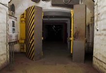 Switzerland’s $250 Million Gamble—What’s Hiding Underground? Entrance to an underground bunker with large heavy doors and a sign