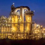 Rockefeller’s Bold Move Rattles ExxonMobil An industrial facility with illuminated structures at night