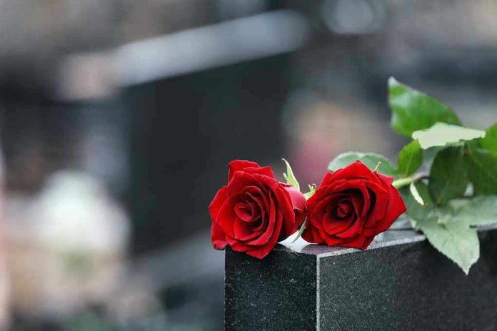 1615218823 Two red roses on a gravestone