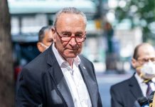 Shutdown Chaos Grips Washington — Nobody Budges Man in suit and red glasses standing outside