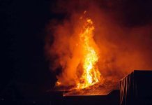 Building engulfed in large flames at night.