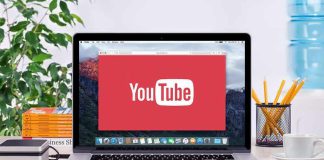 YouTube logo on a laptop screen on desk.