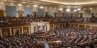 Large assembly in a government legislative chamber.