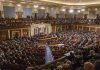 Large assembly in a government legislative chamber.