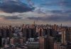 A panoramic view of New York City skyline during sunset with clouds