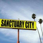 Blue Cartels Hijack Democrat Cities Sanctuary City sign with palm trees and sky.