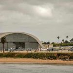 Aircraft hangar with helicopters near the beach.