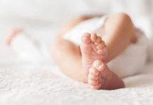 Close-up of baby feet lying on blanket.