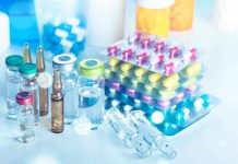 This Drug Now DECLARED as a WMD Vials and blister packs of pills on table.