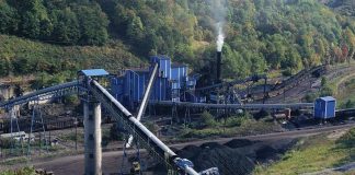 Industrial coal processing plant with conveyor belts and smokestack.