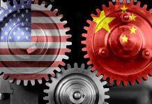 Beijing Panics As America-First Tariffs Bite Interlocking gears with USA and China flags.